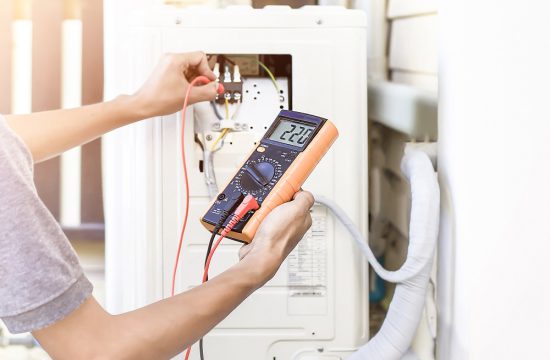 Air conditioner repairman using electricity meter to check air c